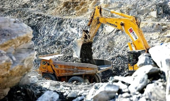 Excavator moving rock at an open mining site